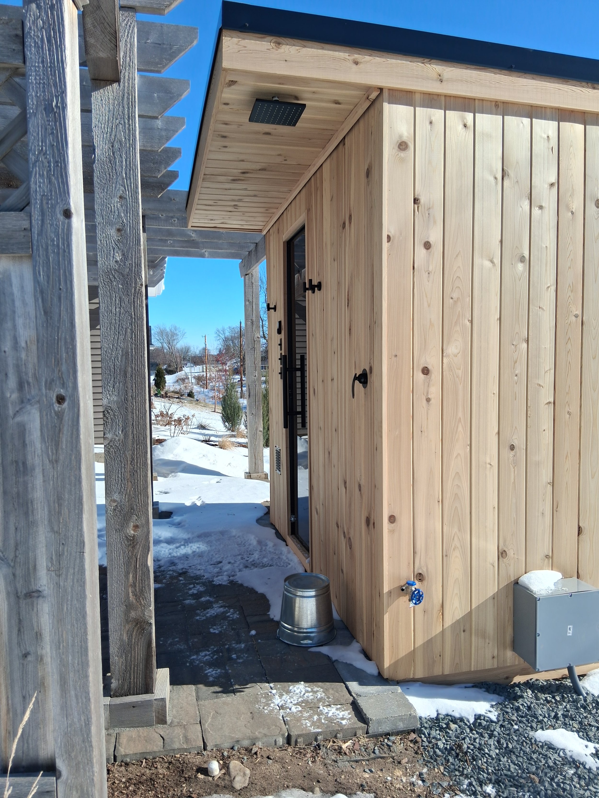 Sauna on patio in snow with bucket