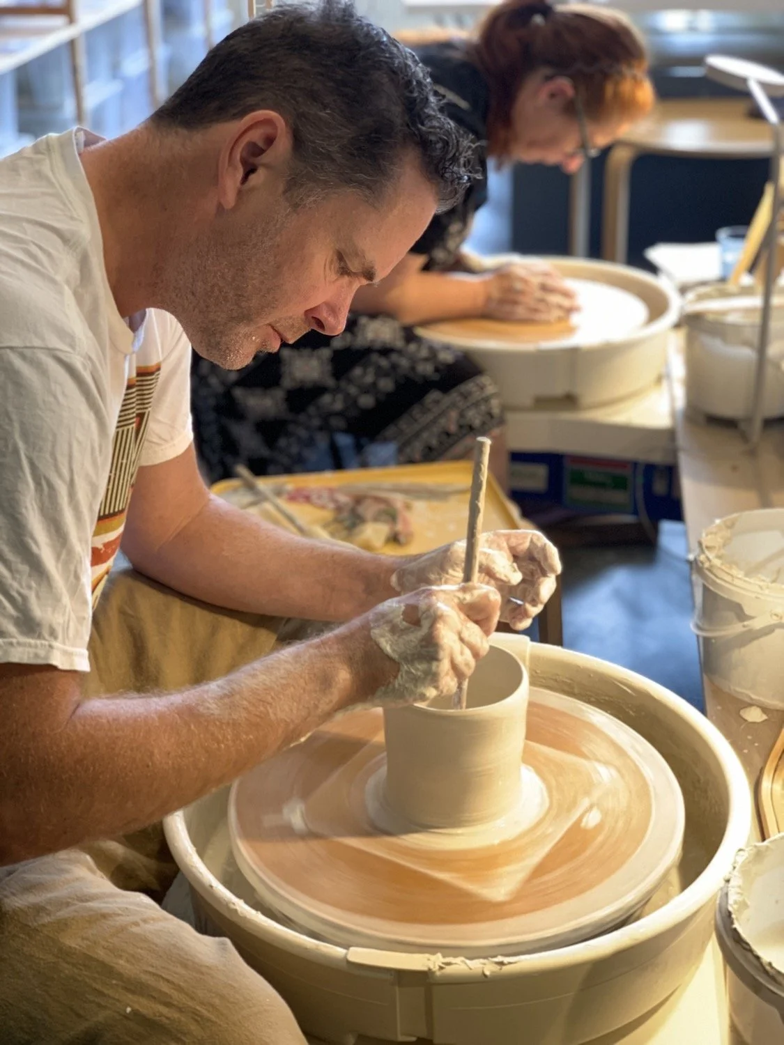 A man throwing a porcelain cylinder on the potter's wheel