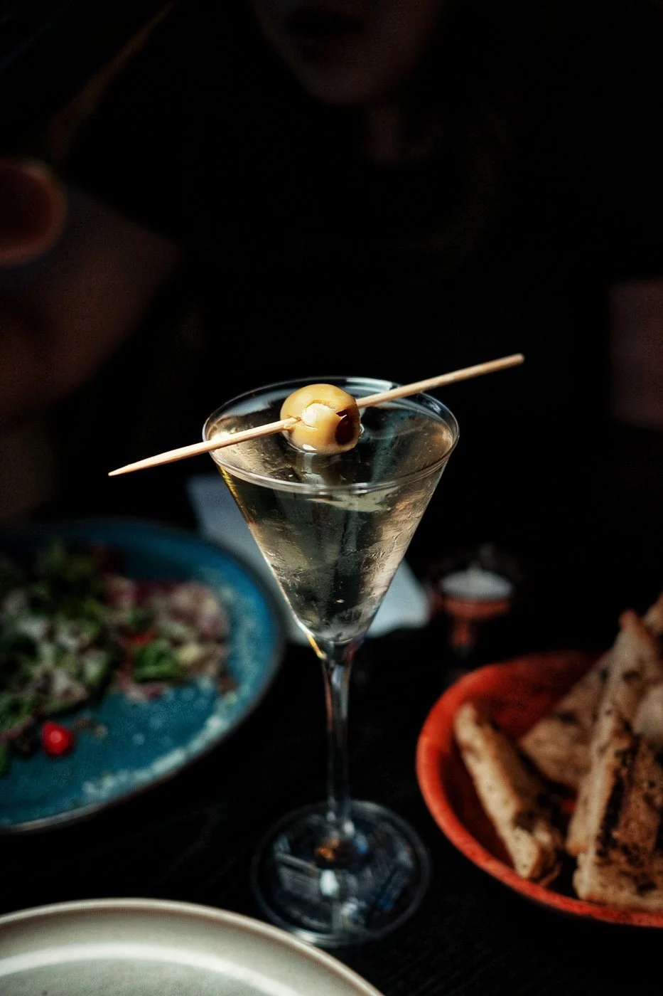 A chilled Dirty Martini with Olive Garnish.