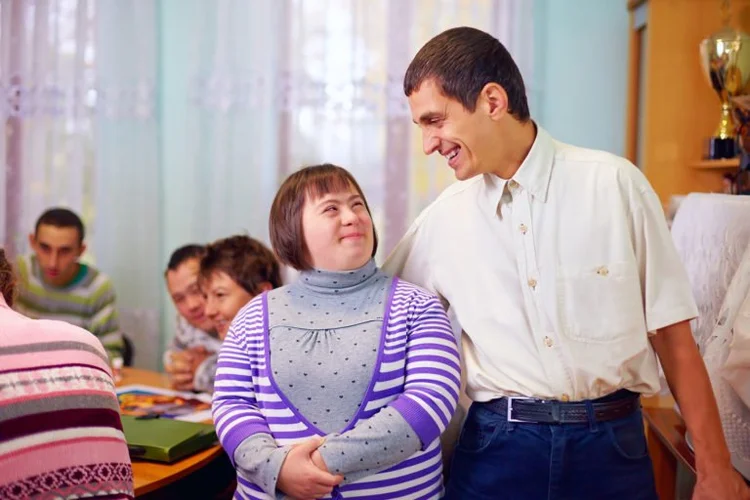 A support professional and an adult client smiling together