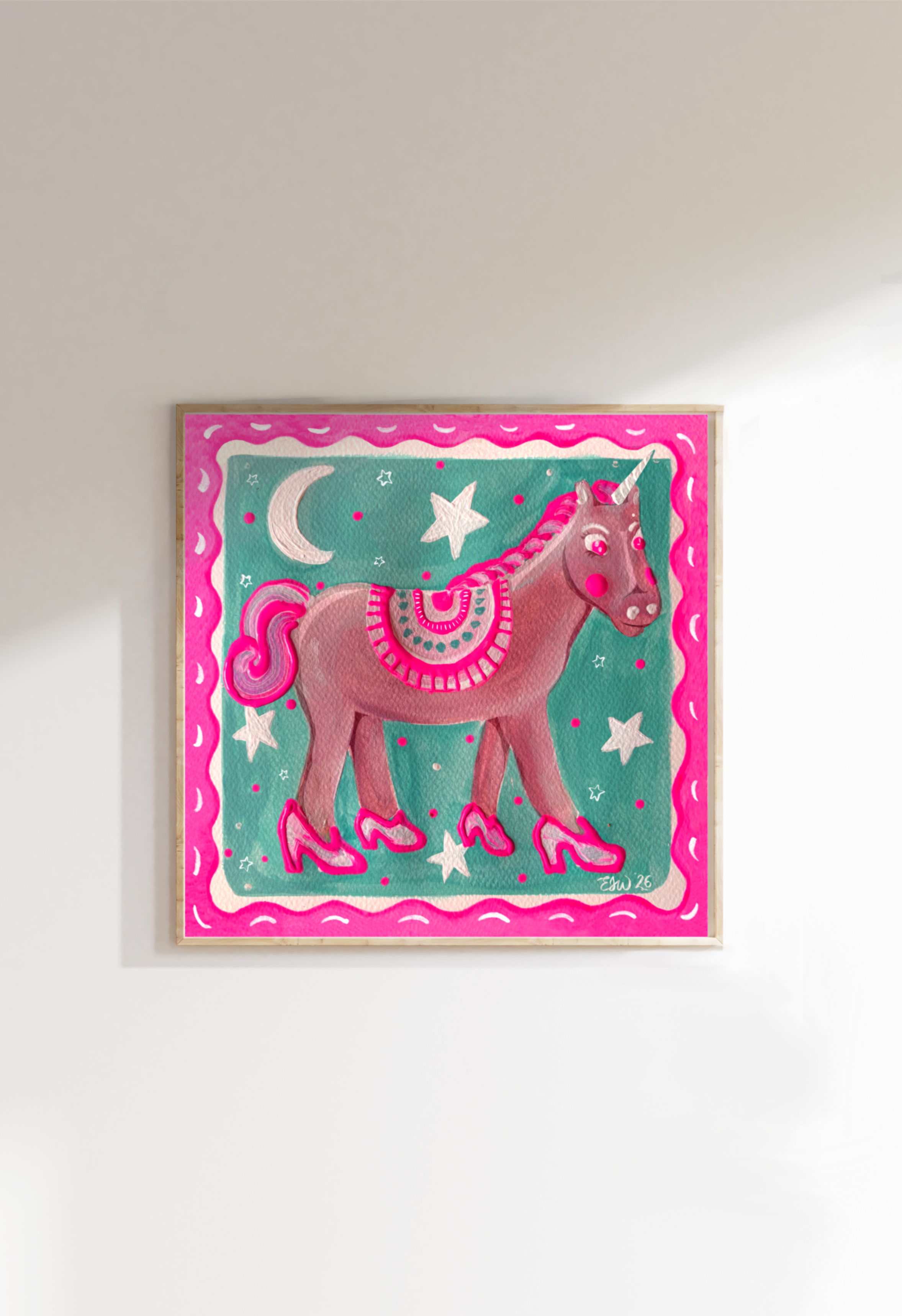 Colorful handpainted fine art print by Emma Winterschladen of a pink unicorn with a rainbow mane and tail, wearing pink shoes, surrounded by moon, star, and dot patterns, with a pink wavy border.