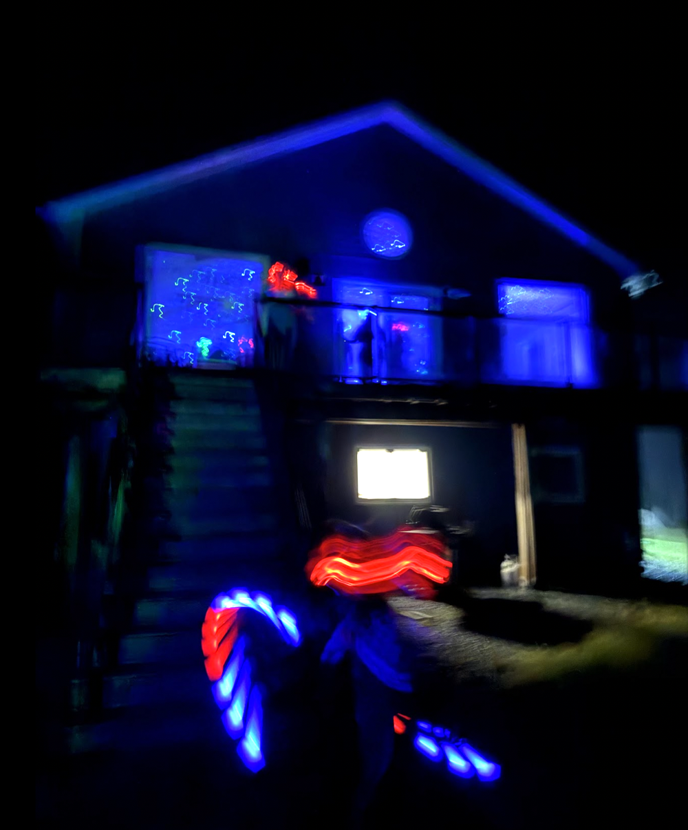 the beach house lit up at night, full of silent disco dancers