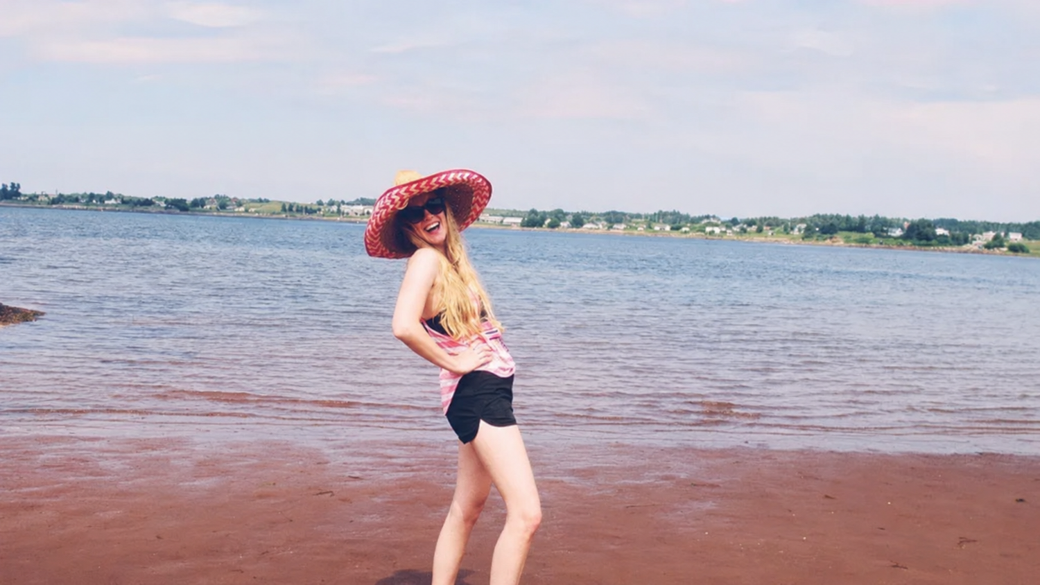 andie in a hat on the beach at pugwash