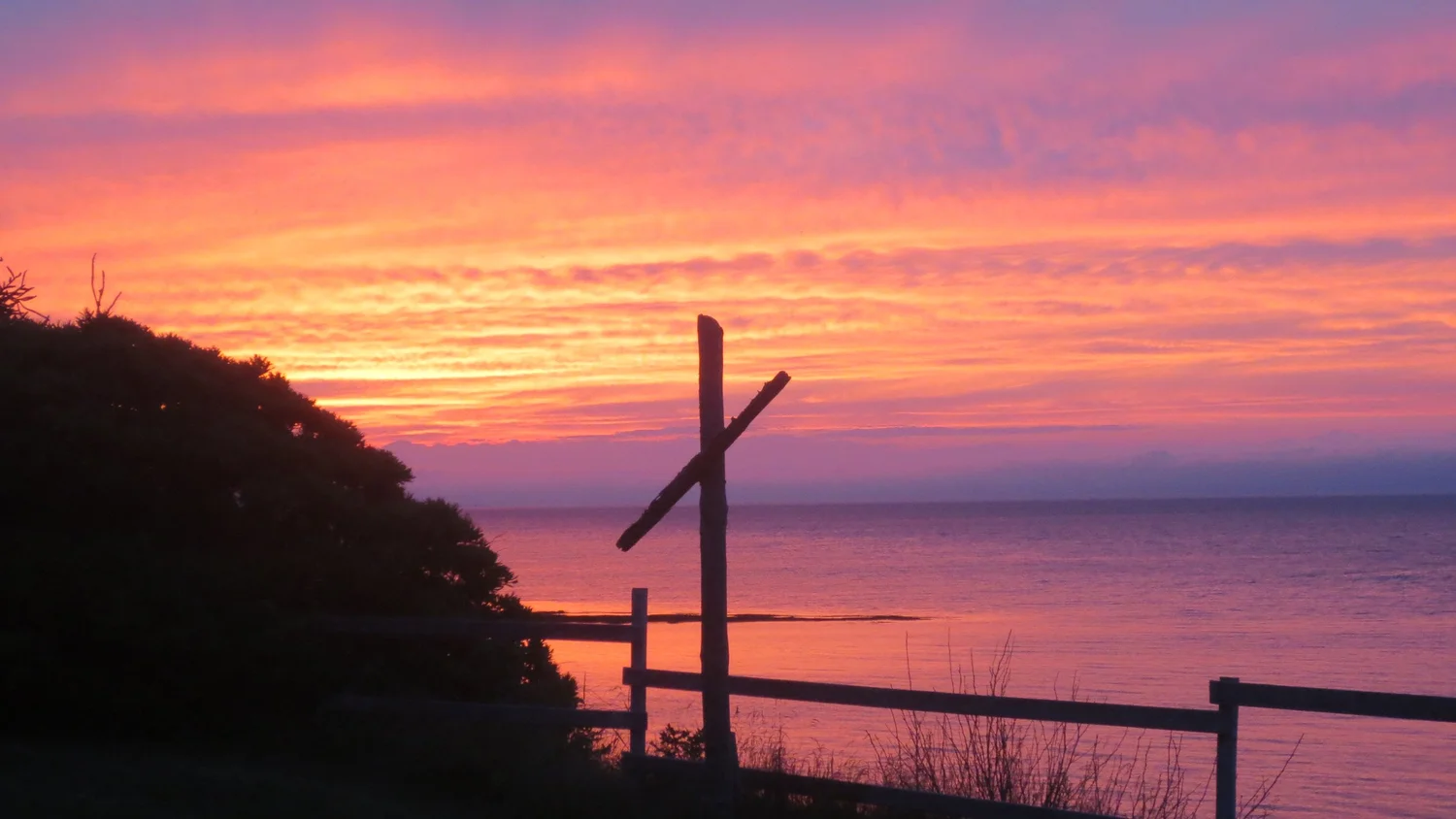 sunset burning orange and pink over the water at camp pagweak