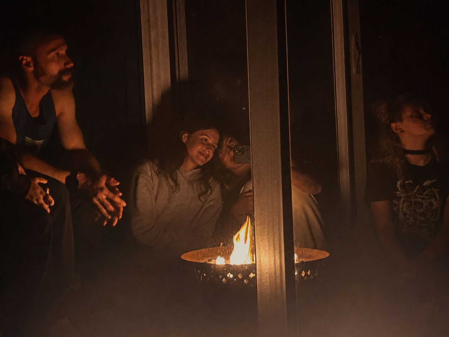friends gathered closely around a campfire, laughing and connecting