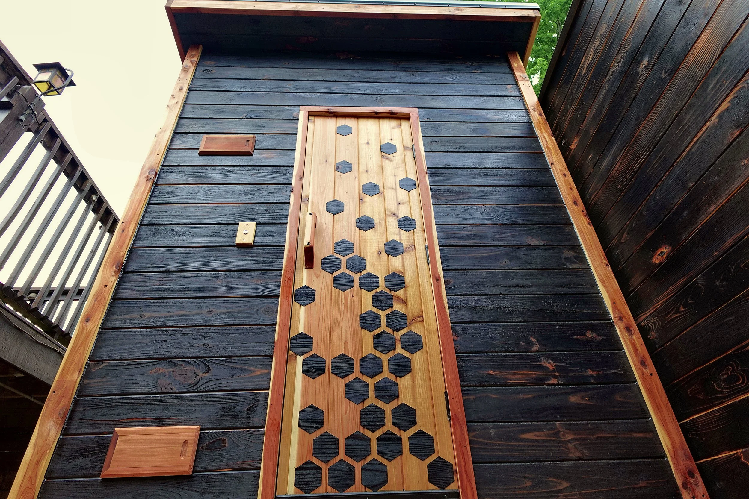 Sauna from solid cedar and burnt pine. 
Torched and oiled pine exterior ( yuki sugi, or shou sugi ban ), with oiled cedar trim.  Custom benches, 3" thick door, touch operated waterproof LED' s, and double pane tempered window make this an extremely f