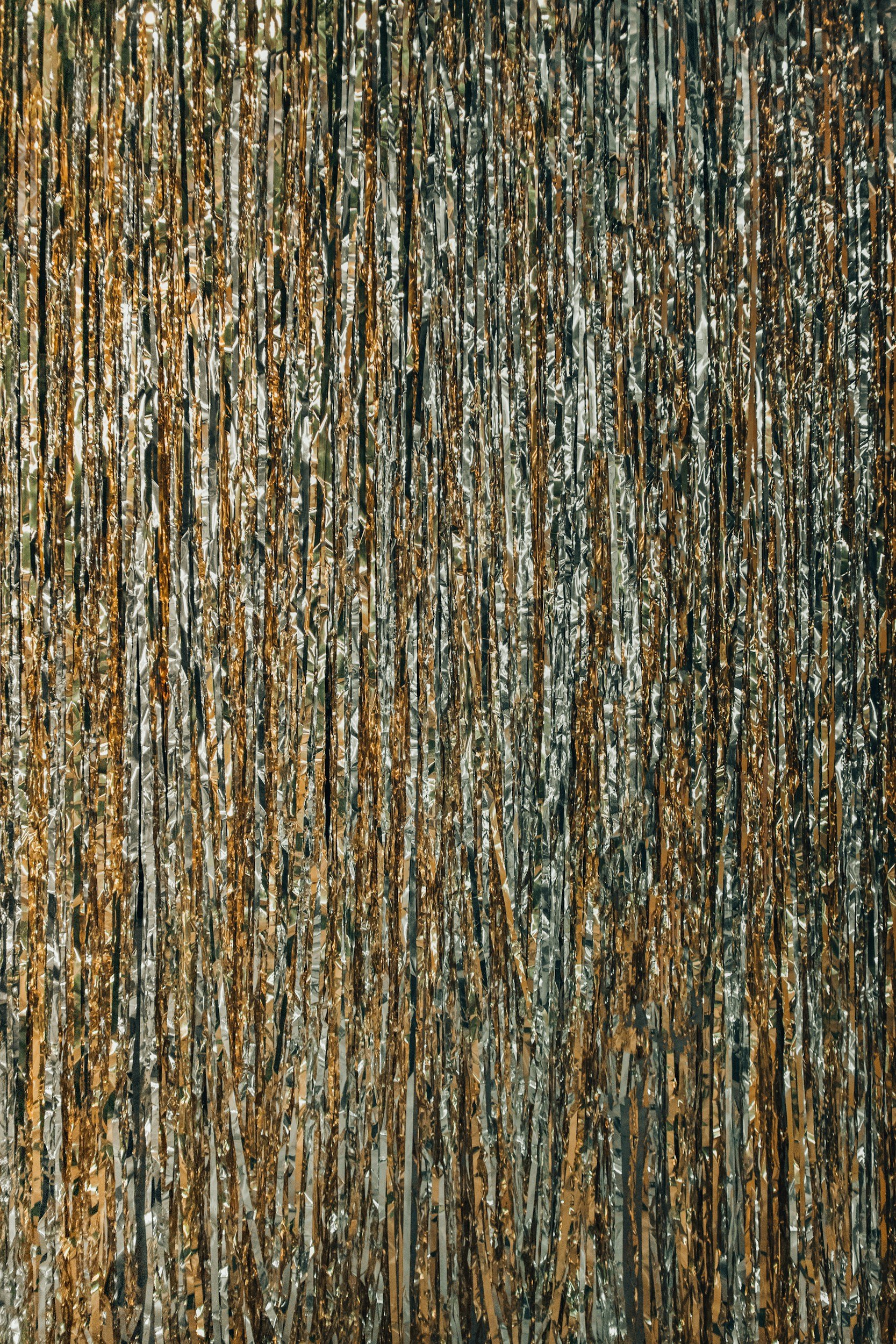 Gold and silver metallic tinsel streamers hanging vertically, creating a festive backdrop.