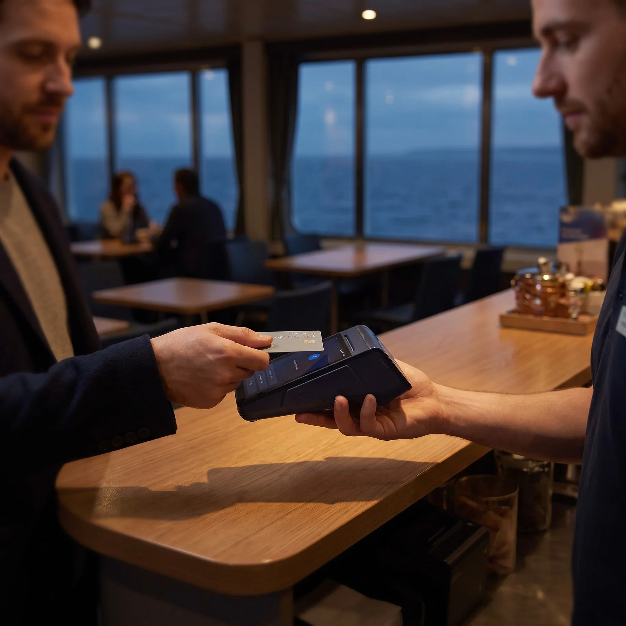 Passenger paying by contactless card on an eMenu smart card machine in a ferry cafe
