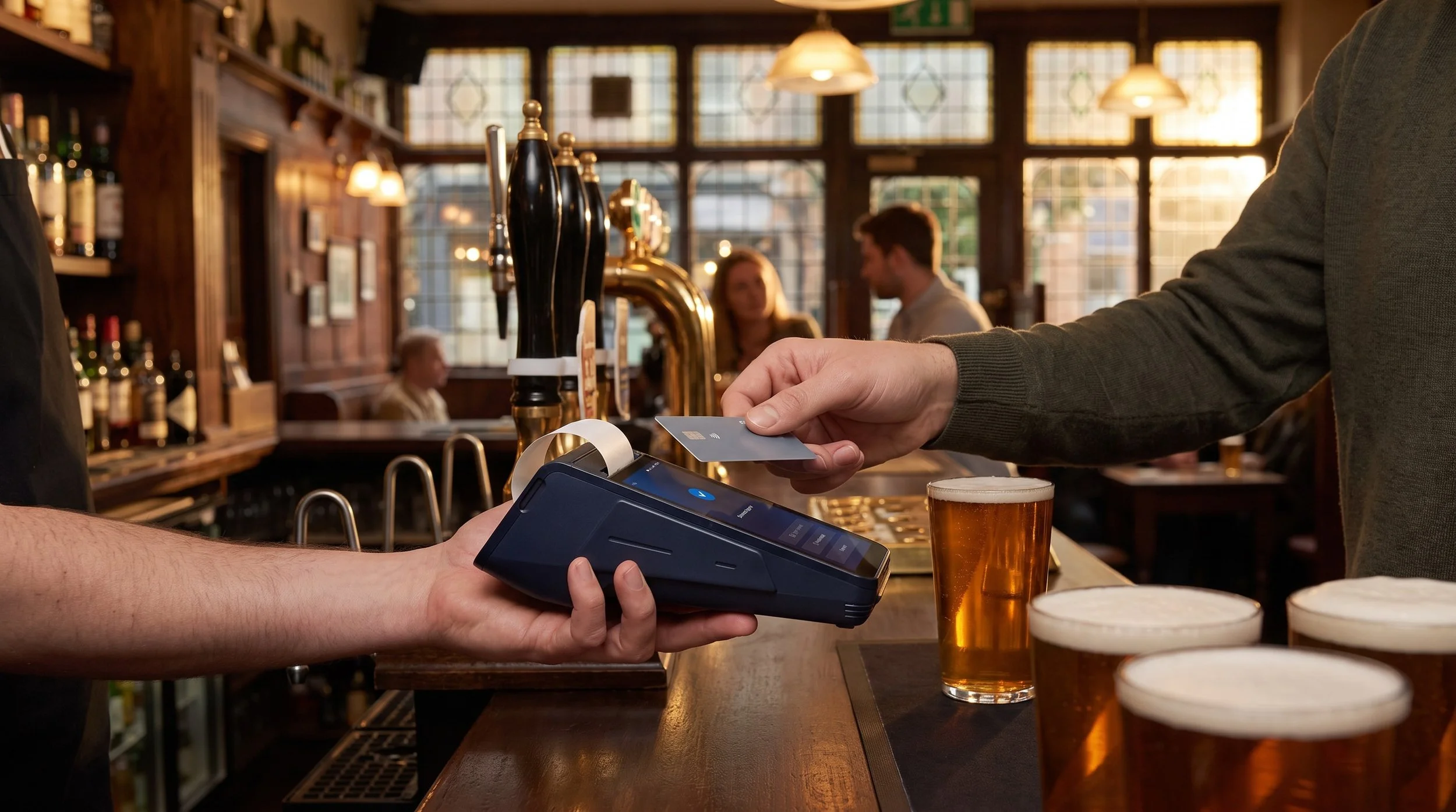 Customer tapping a contactless card on an eMenu smart card machine at a pub bar