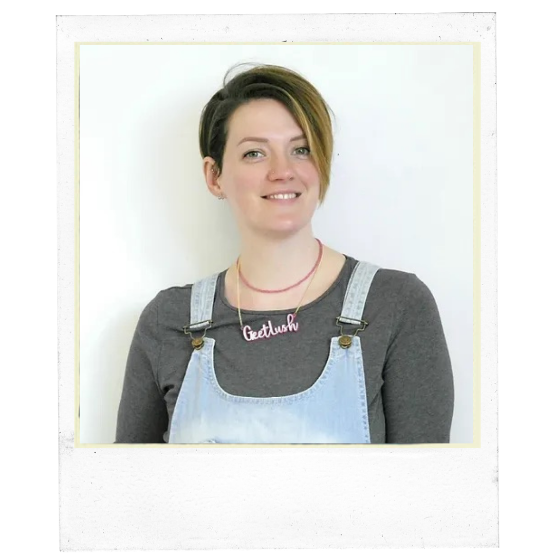 Person wearing a gray long-sleeve shirt with light blue denim overalls, and a necklace with the text "Get Lush."