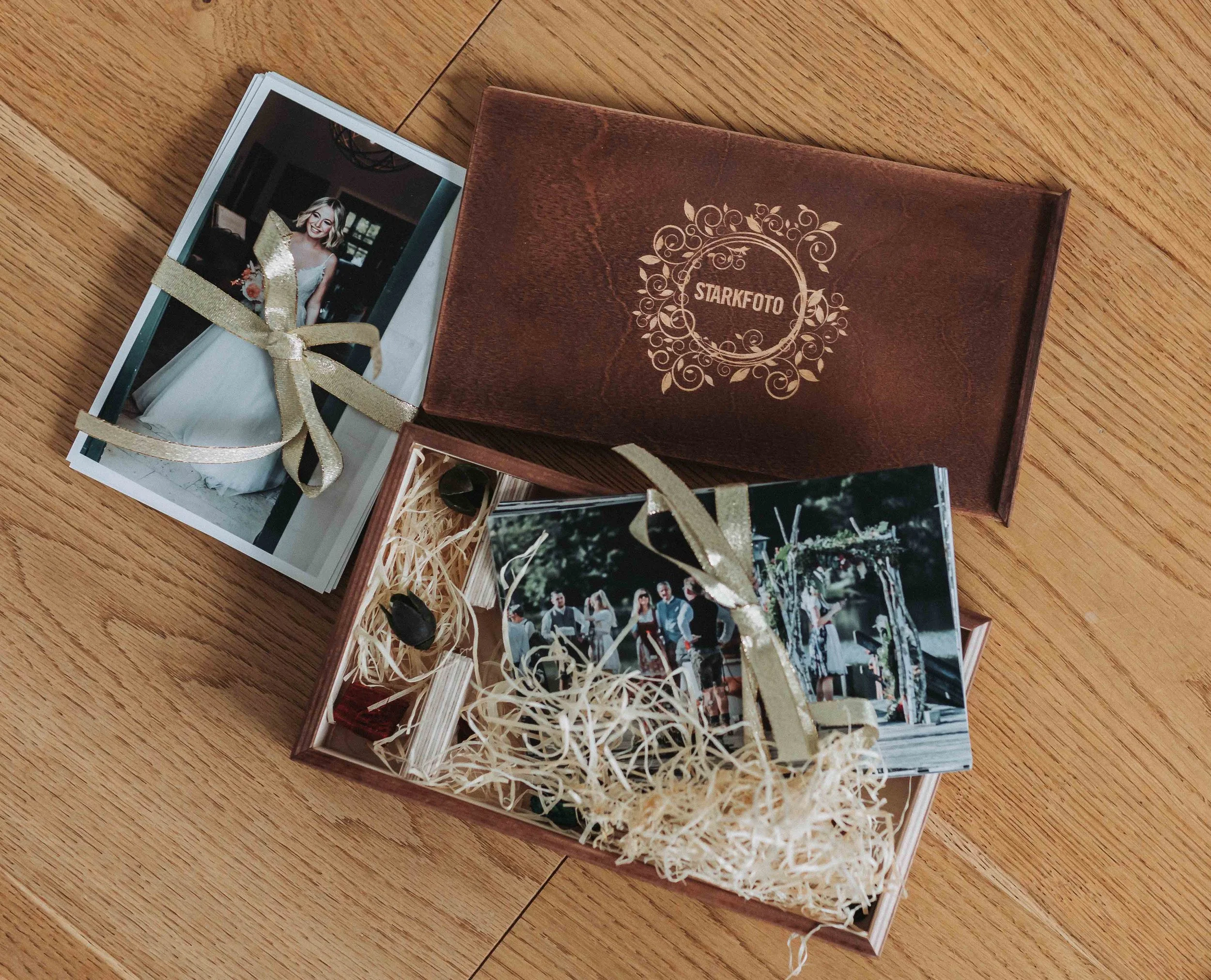 Fotokarten in einem Holzschachtel, verziert mit einem Goldband, auf einem Holzfußboden