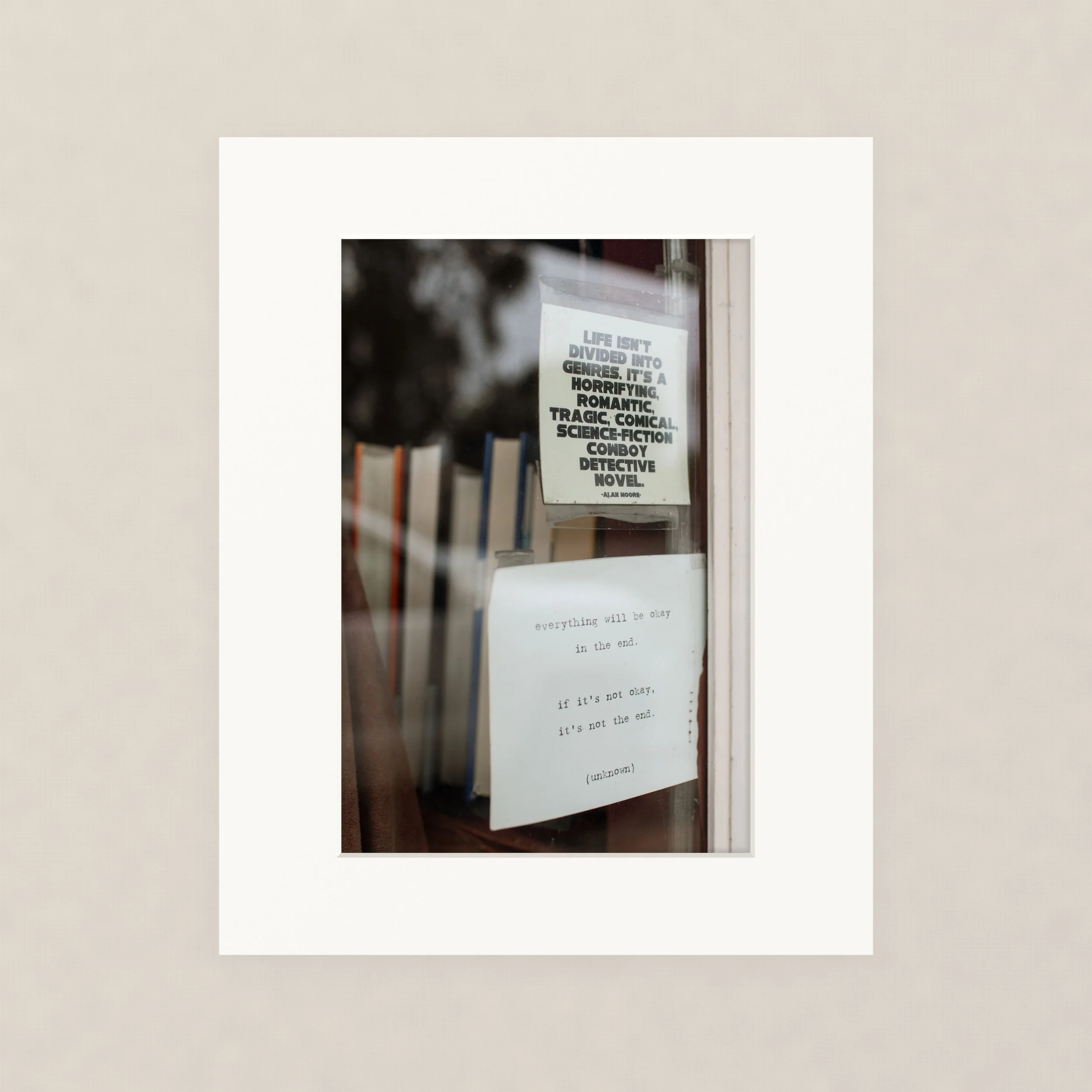 Santa Barara fine art photography print: A printed quote on a piece of paper hug in a bookstore window. The quote reads, 'Life isn't divided into genres. It's a horrifying, romantic, tragic, comic, science-fiction, cowboy detective, novel.'