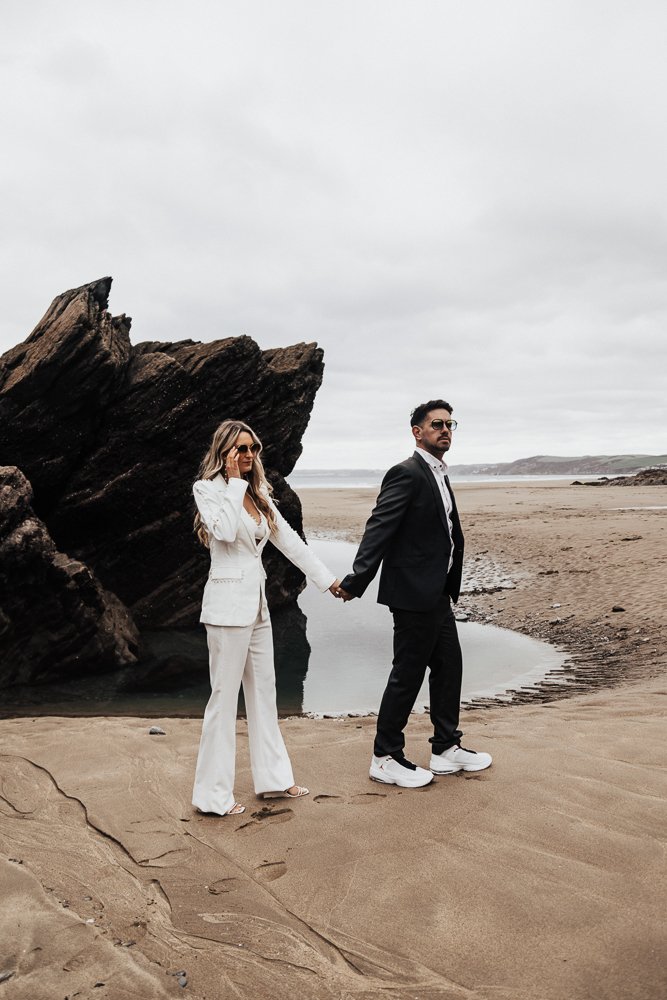 Couple celebrating engagement on Whitsand Bay beach in Cornwall