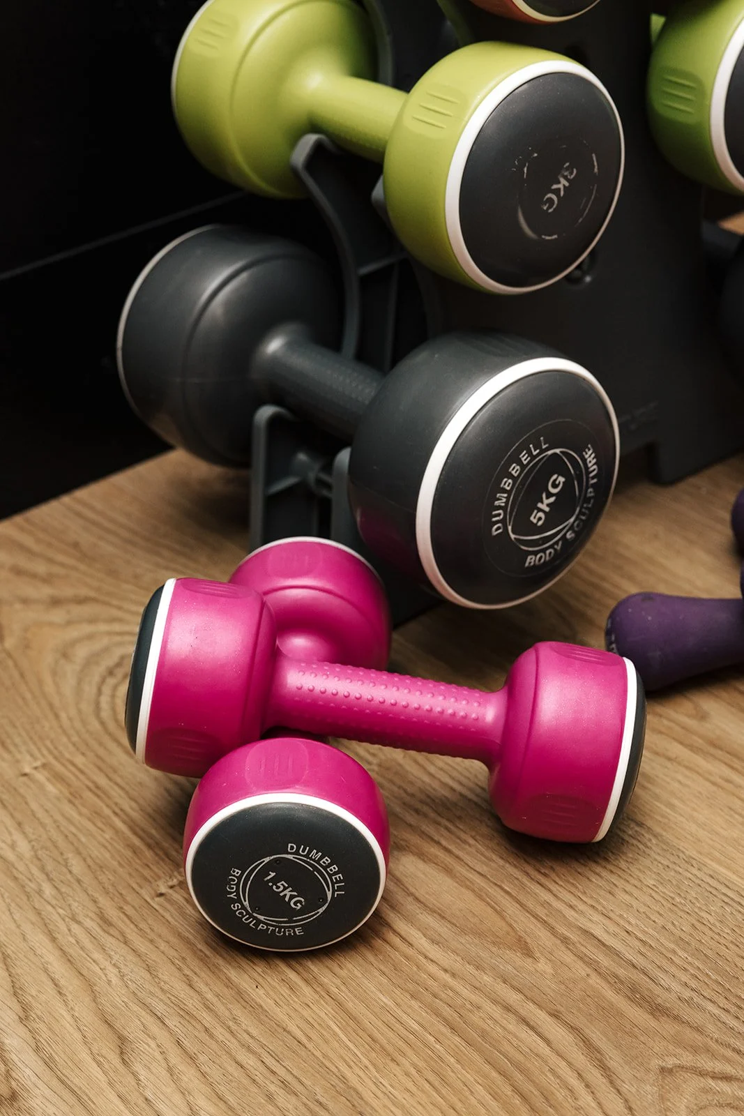 A clean, modern gym space with women using strength training equipment