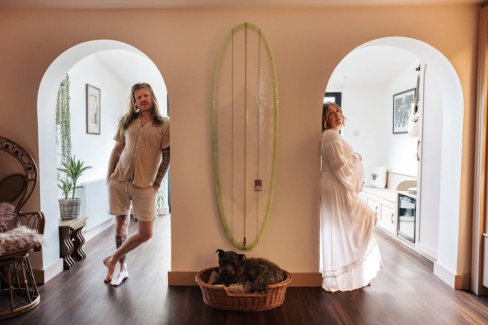Pregnant woman in final week of pregnancy being gently posed and directed during at home maternity photoshoot with partner