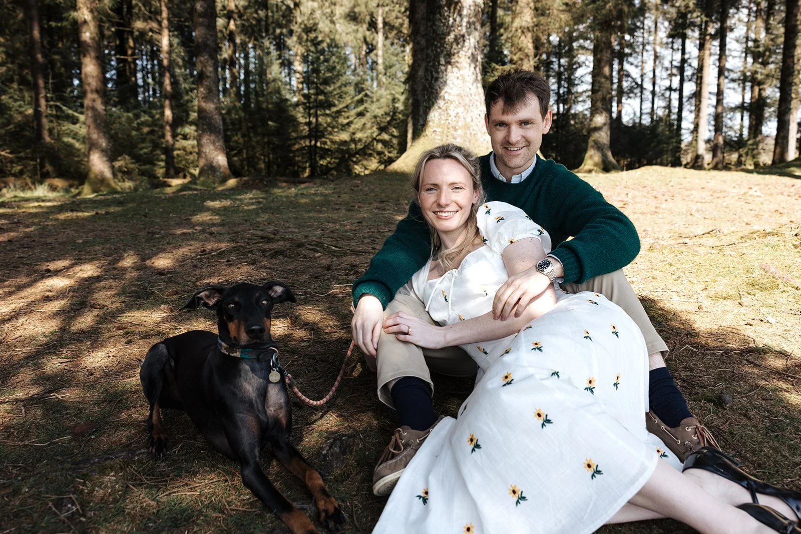 Engagement photoshoot in Dartmoor woodland with couple and their dog in a natural outdoor setting