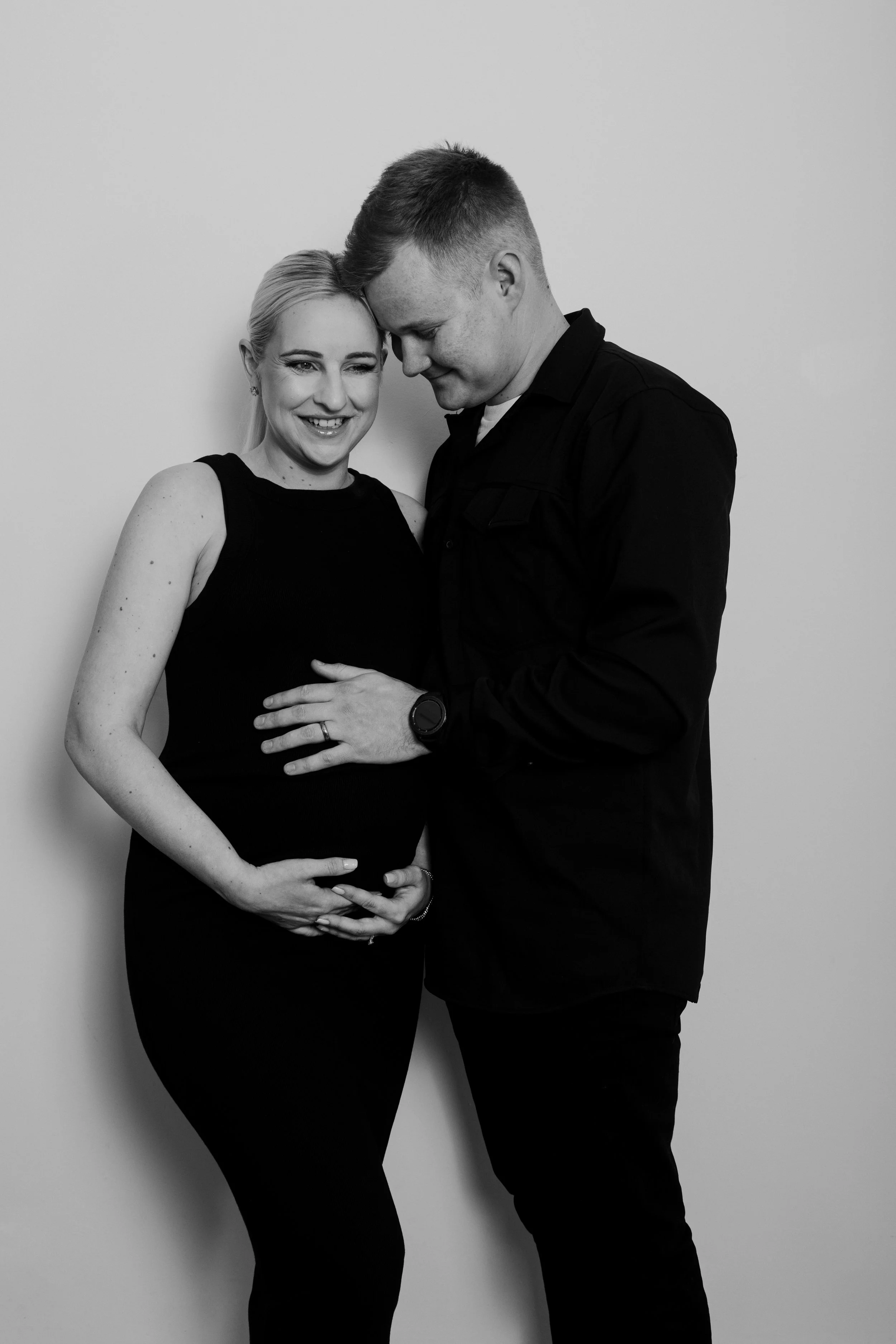 Simple and natural maternity photoshoot pose highlighting pregnancy in a relaxed studio photography session.