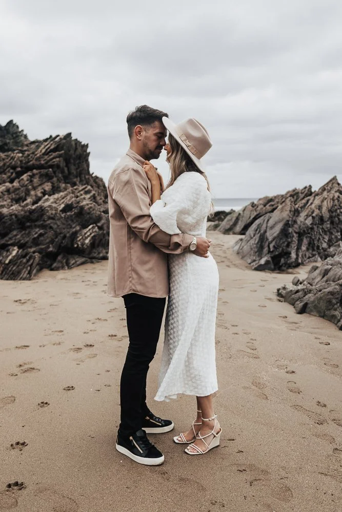 Couple celebrating engagement on Whitsand Bay beach in Cornwall