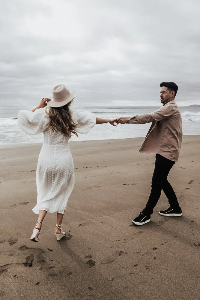 Couple celebrating engagement on Whitsand Bay beach in Cornwall