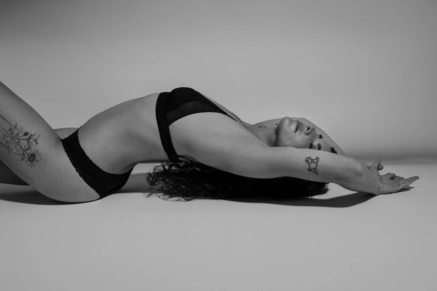 Woman posing for a self-love boudoir portrait session in a studio