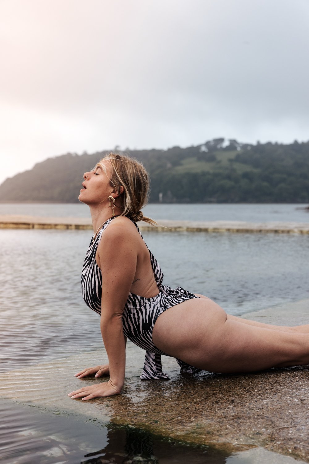 Woman dong yoga in the sea during a self-love portrait session in Plymouth, Devon.