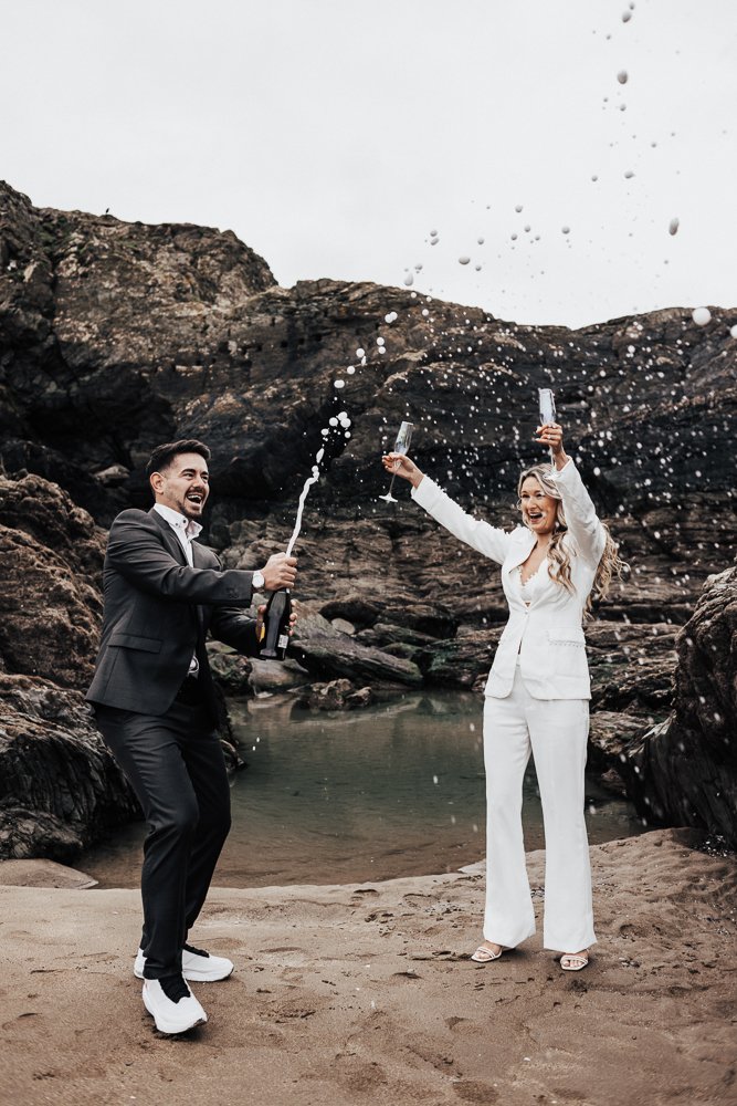 Couple celebrating engagement on Whitsand Bay beach in Cornwall