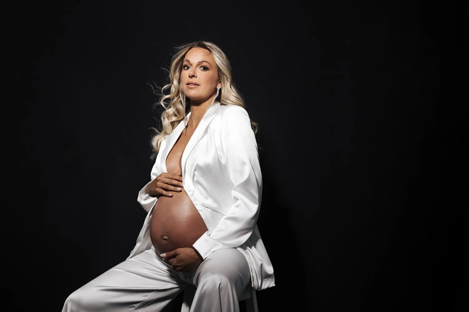 Studio and sunset portraits capture expecting mothers in styled outfits, professional hair & makeup, and timeless, memorable images.