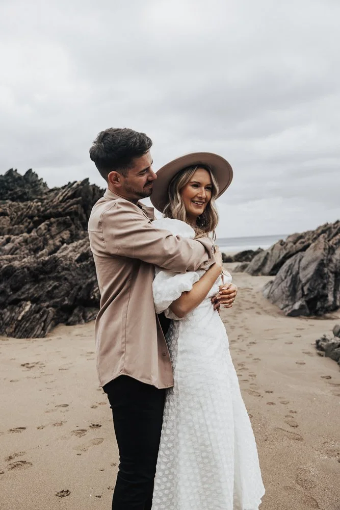Couple celebrating engagement on Whitsand Bay beach in Cornwall