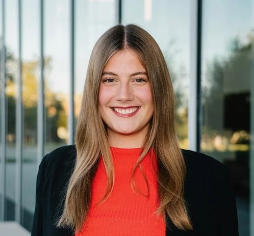A photo of undergraduate Emily Sugg, in a red blouse and black cardigan