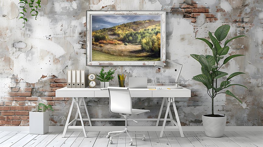 Modern home office with white desk and plants featuring framed autumn landscape wall art on a textured rustic wall