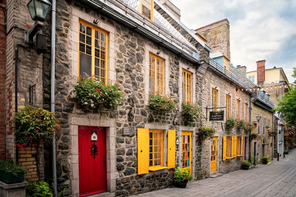 STONE BUILDING WITH YELLOW SHUTTERS AND RED DOOR IN QUEBEC CITY