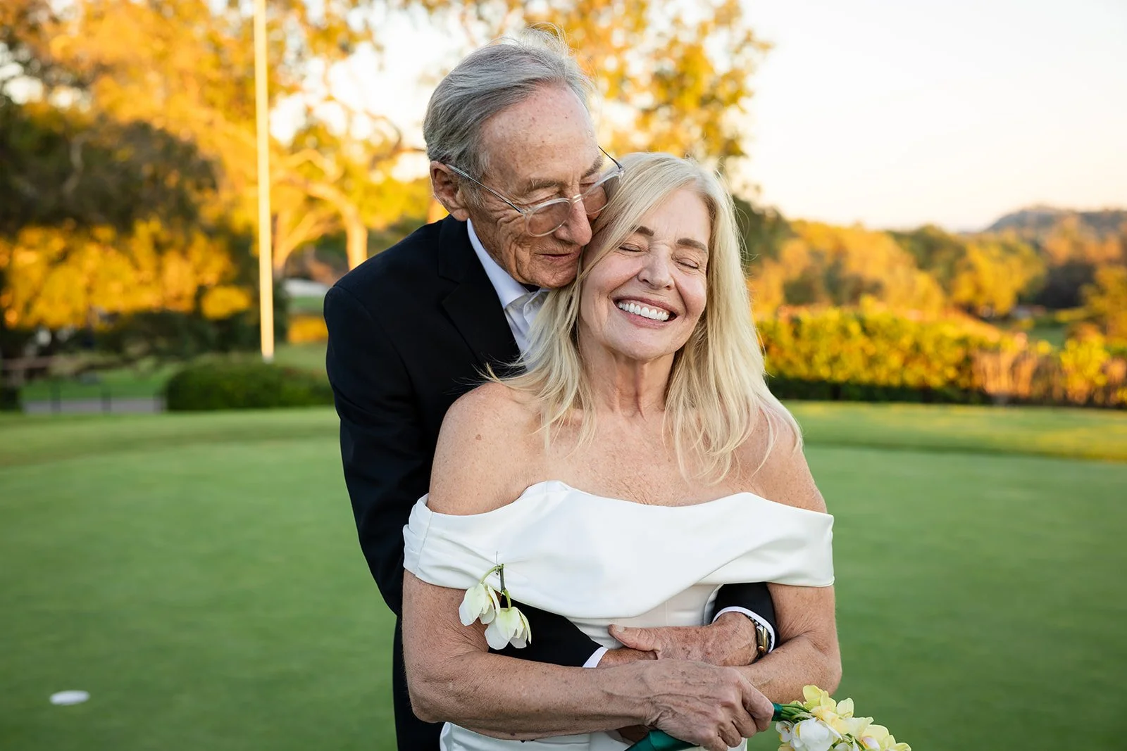 Older newlywed couple embracing after their ceremony