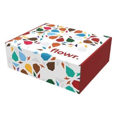 White mailer box printed with colorful holiday graphics and a red side panel, shown with the lid open.