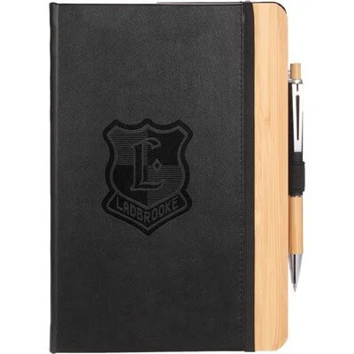 Bamboo-cover journal opened beside a pen.
