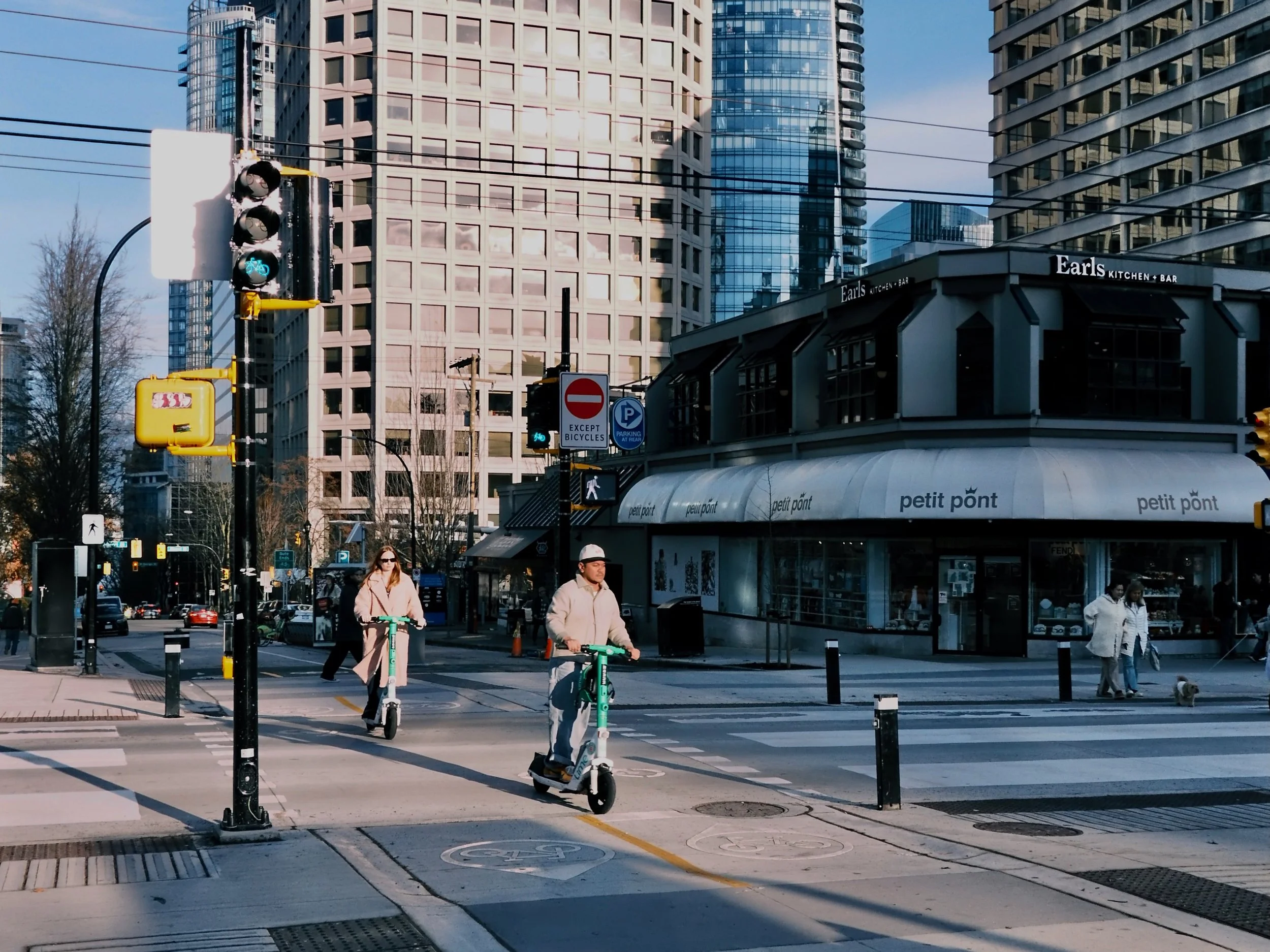 People scooting across Robson Street in Vancouver