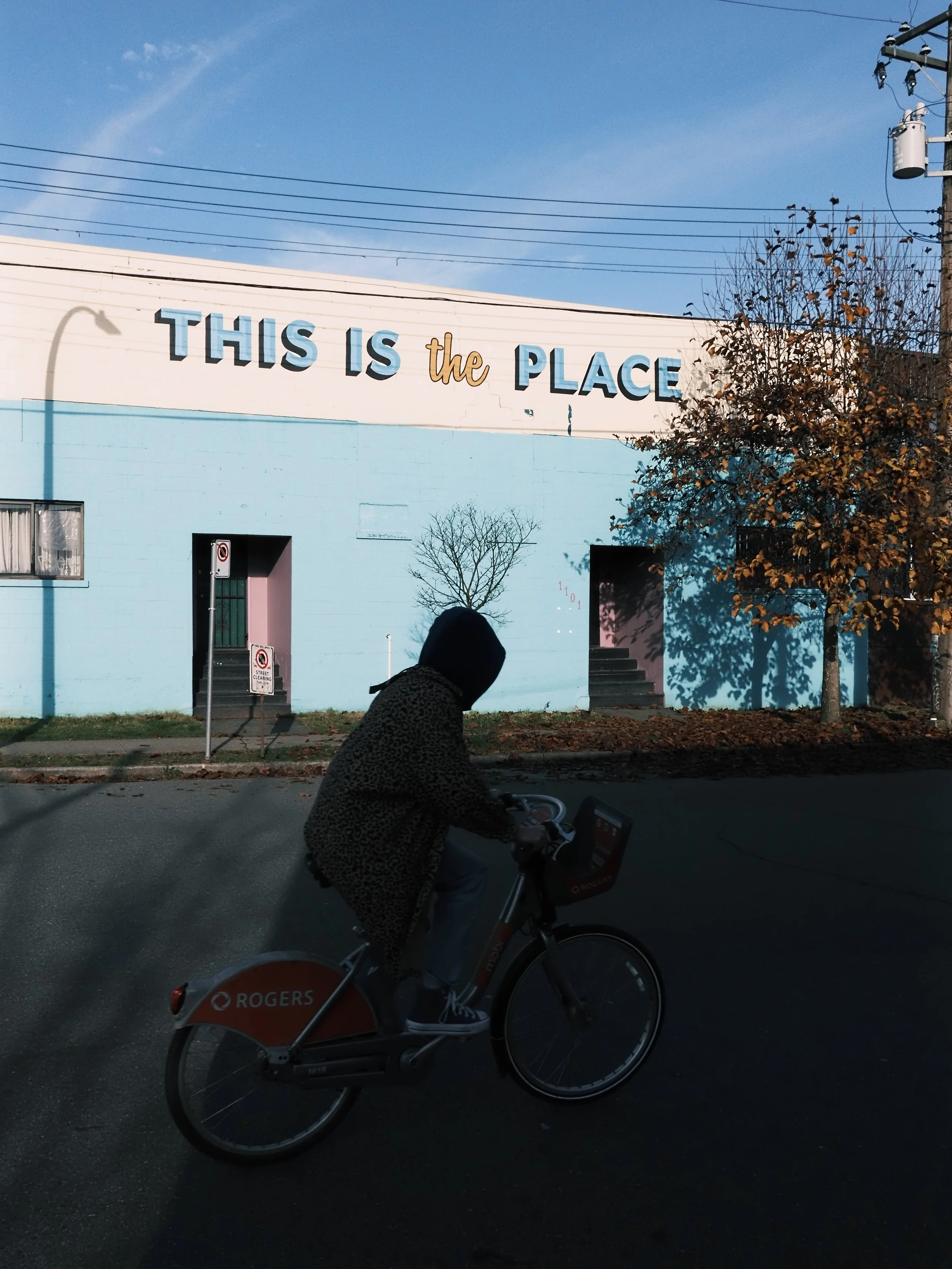Person cycling by building that says this is the place