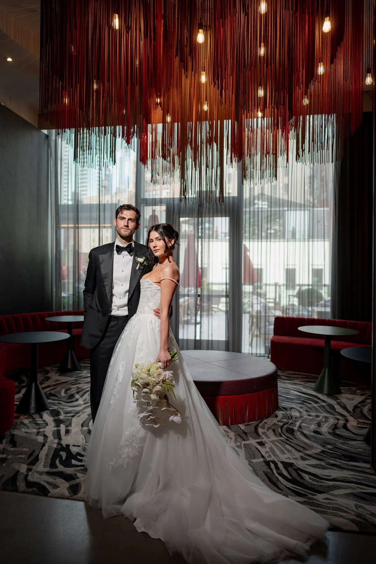 Couple portrait in red fringe lounge Virgin Hotels New York wedding