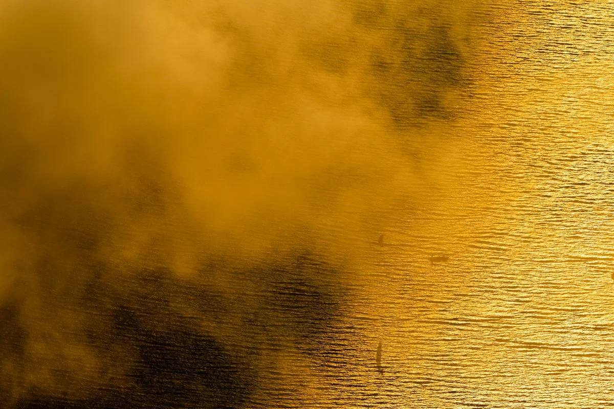 Wolken über dem windigen Wasser des Achensee, in der Großansicht mit Windsurfer