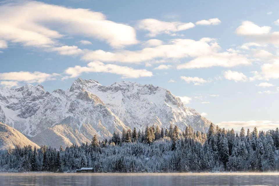 Bootshaus und Karwendel im leichten Nebel und Abendlicht im Winter am Barmsee.