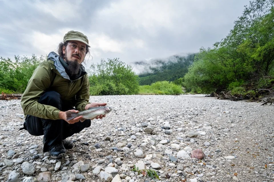 Selfie mit großer Regenbogenforelle im ausgetrockneten Bachbett der Isar bei Wallgau
