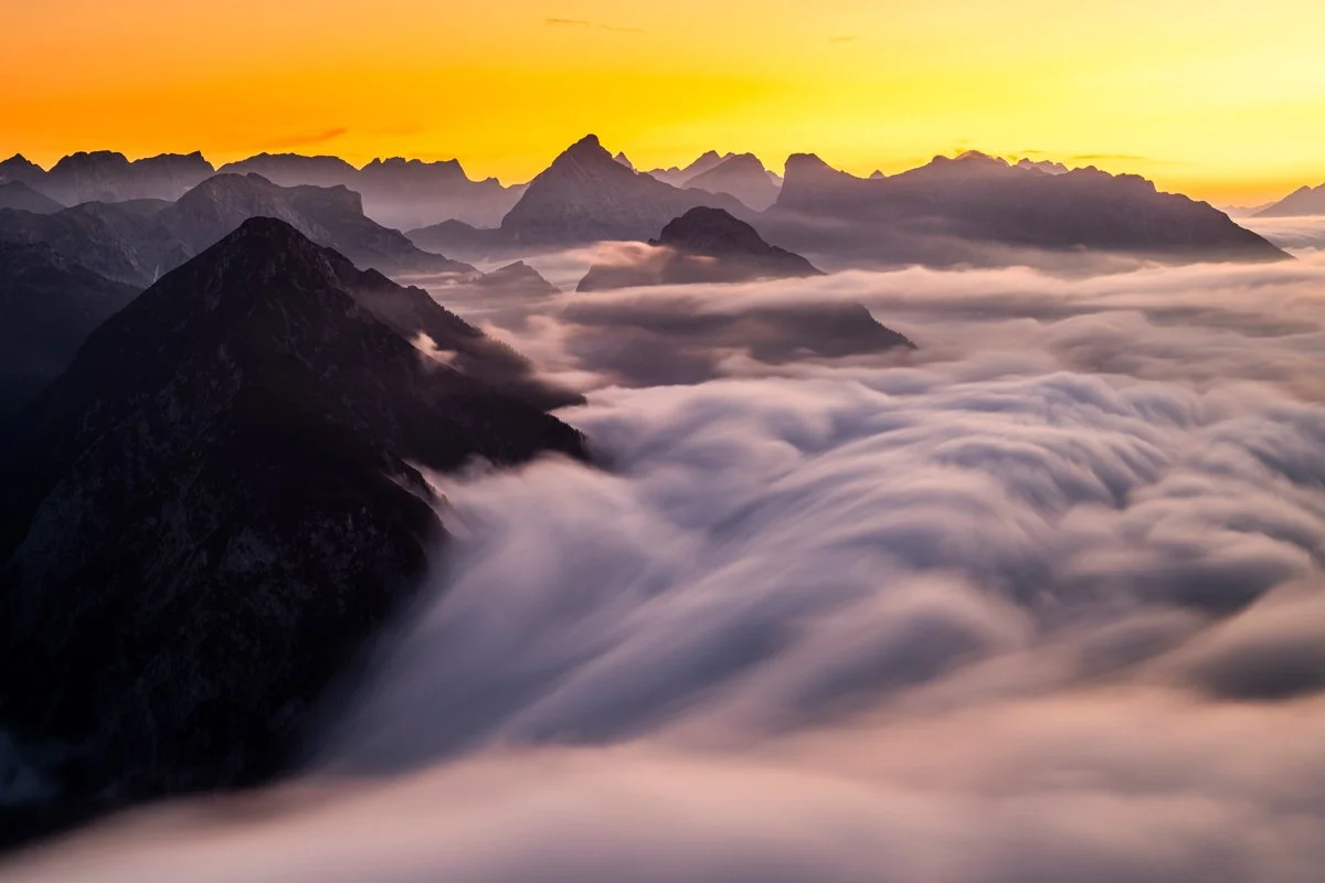 Hochnebel zieht vom Achensee und Karwendel in Richtung Inntal während Sonnenuntergang.