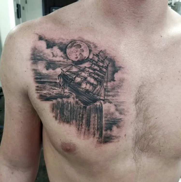 billy_sarno_huntington_beach_tattoo_realism_black_and_gray_clipper_ship_falling_off_waterfall_edge_of_world_clouds_moon_chest.jpeg