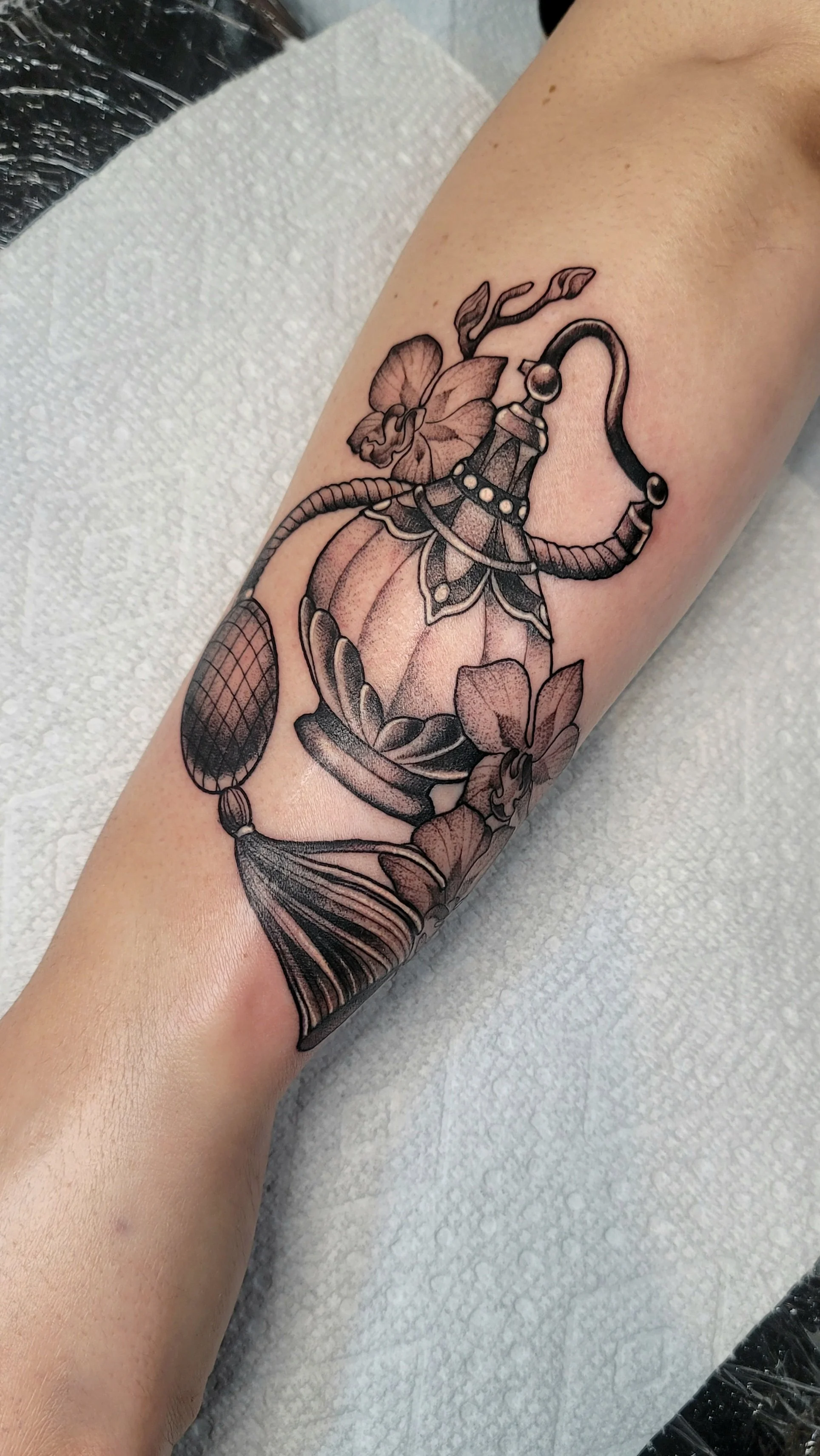 alayna_magnan_huntington_beach_tattoo_neotraditional_black_and_gray_stipple_perfume_bottle_orchid_stems_forearm.jpg