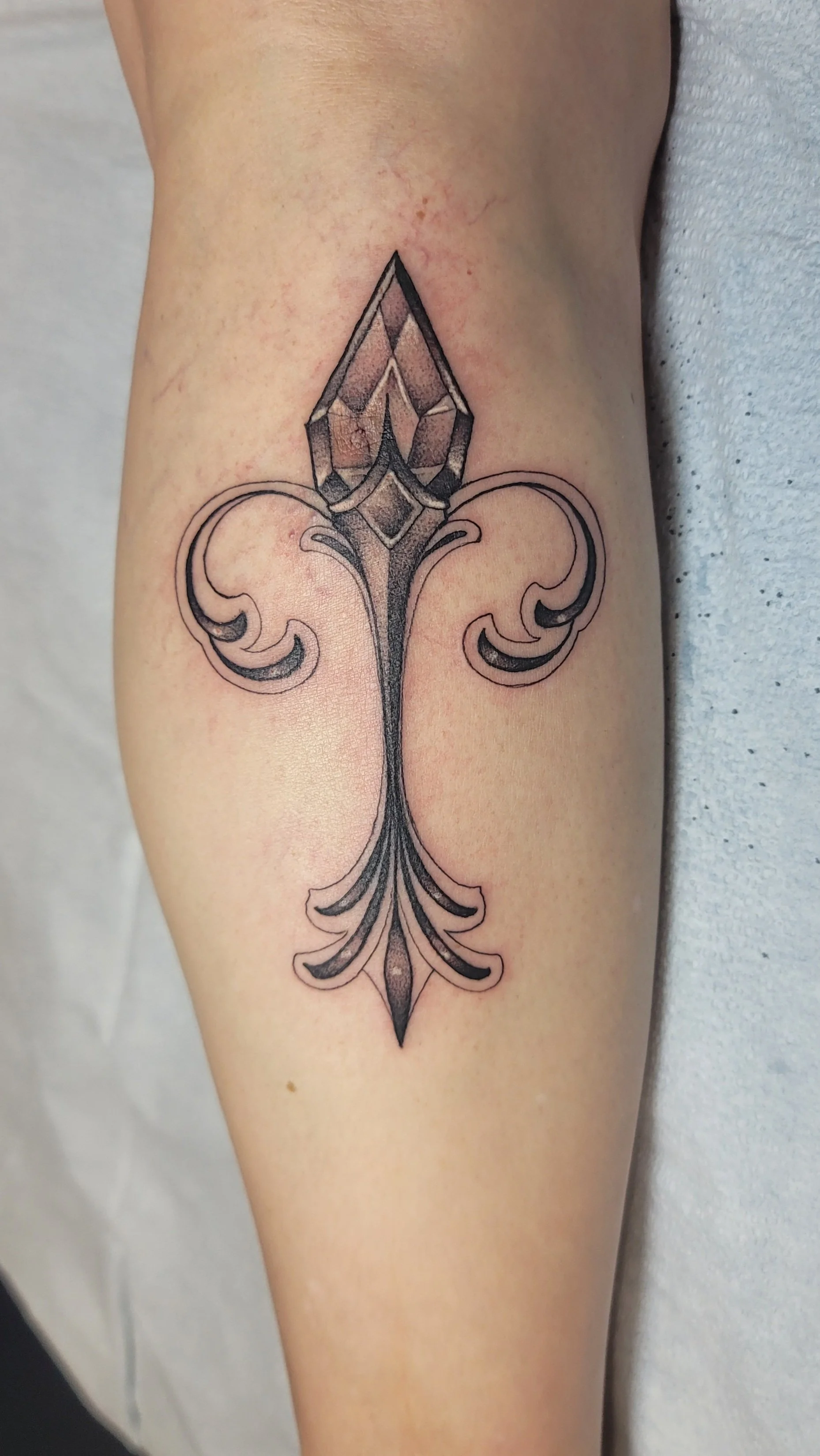 alayna_magnan_huntington_beach_tattoo_neotraditional_black_and_gray_ornamental_fleur_de_lis_gem_calf.jpg