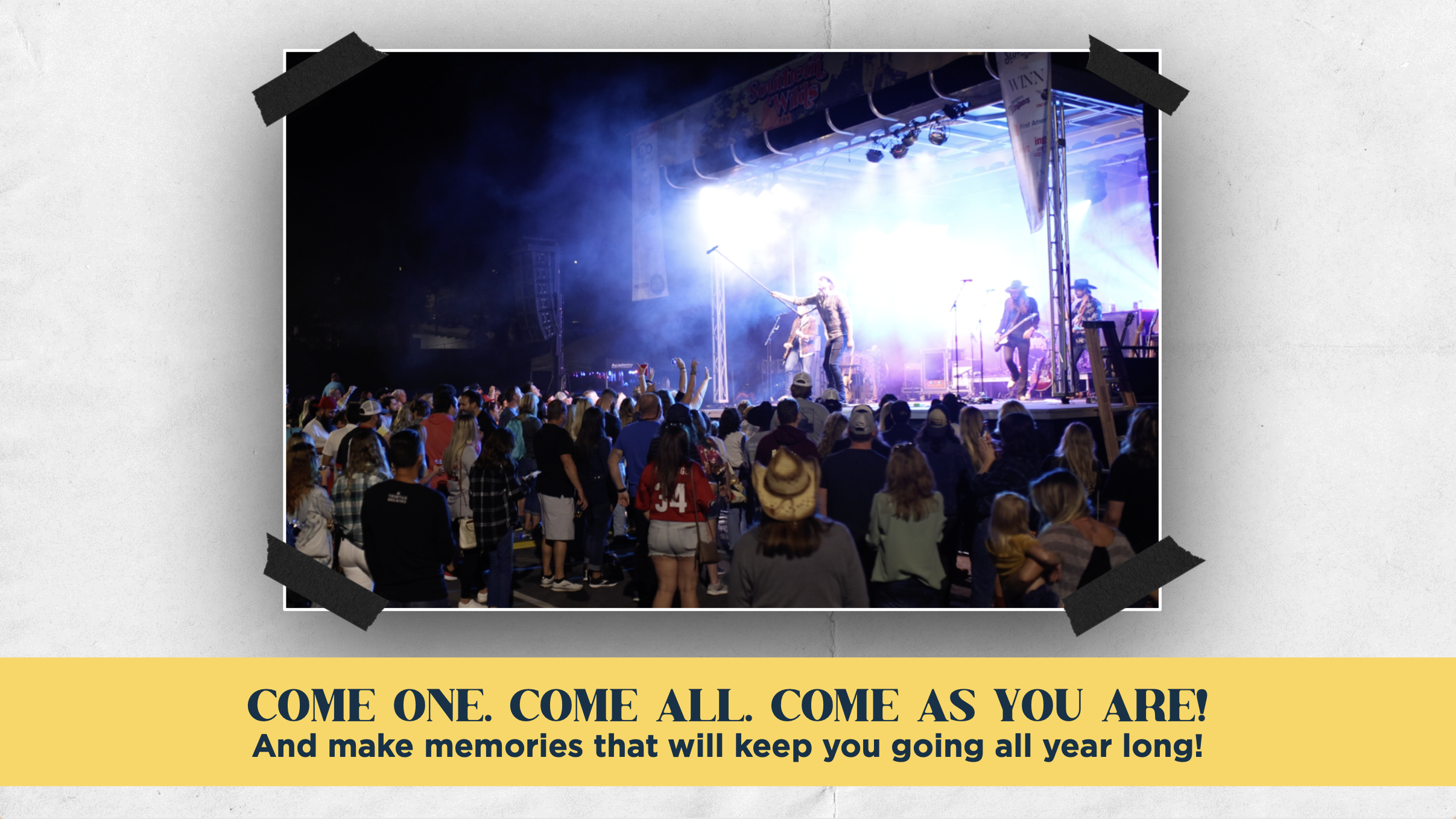 People watching a country music band perform on an outdoor stage at night with bright stage lights and smoke effects.
