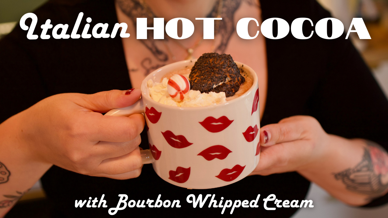Woman holding mug of hot chocolate with a burnt marshmallow, peppermint and whipped cream on top.