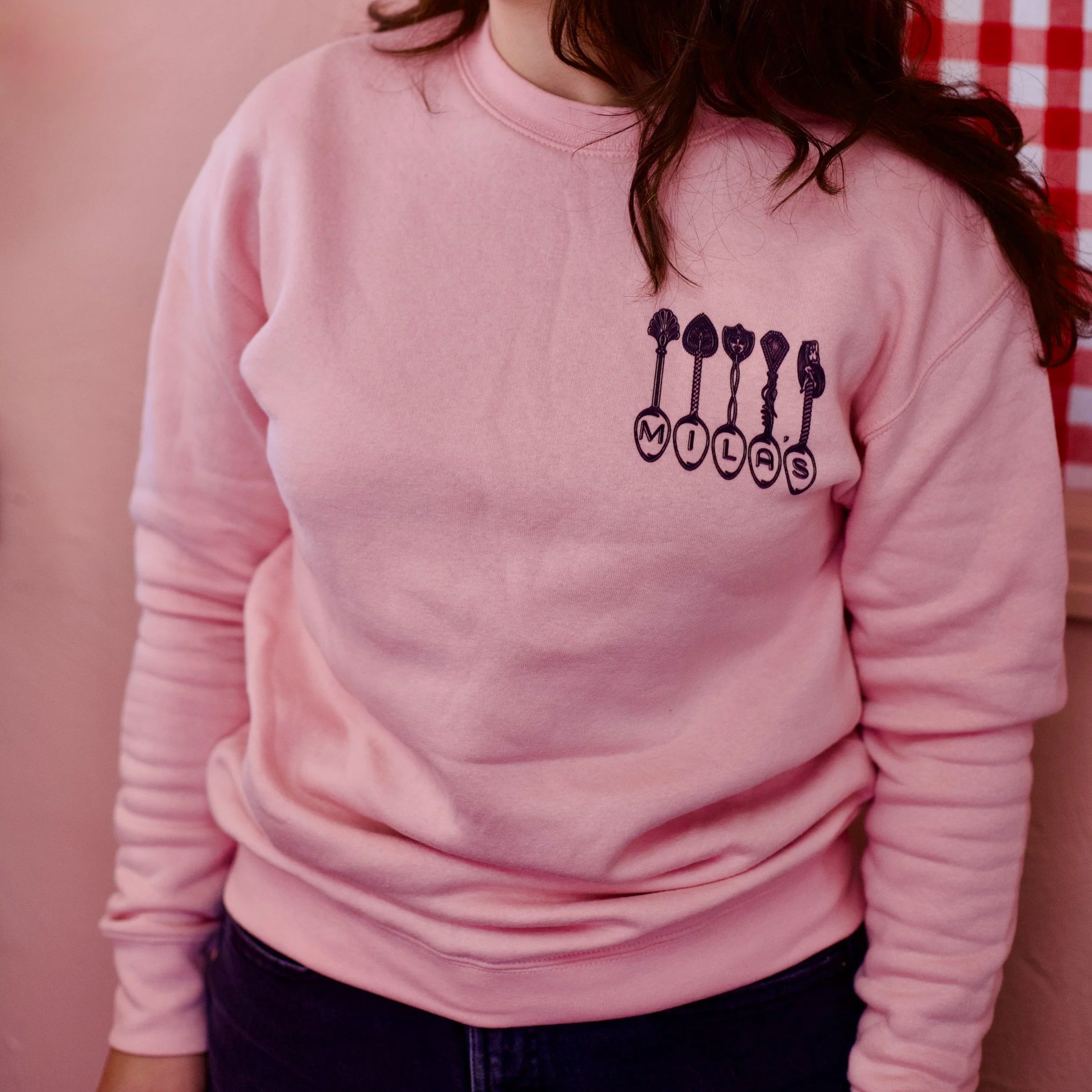 Light pink sweatshirts with vintage spoons spelling out "Mila's"