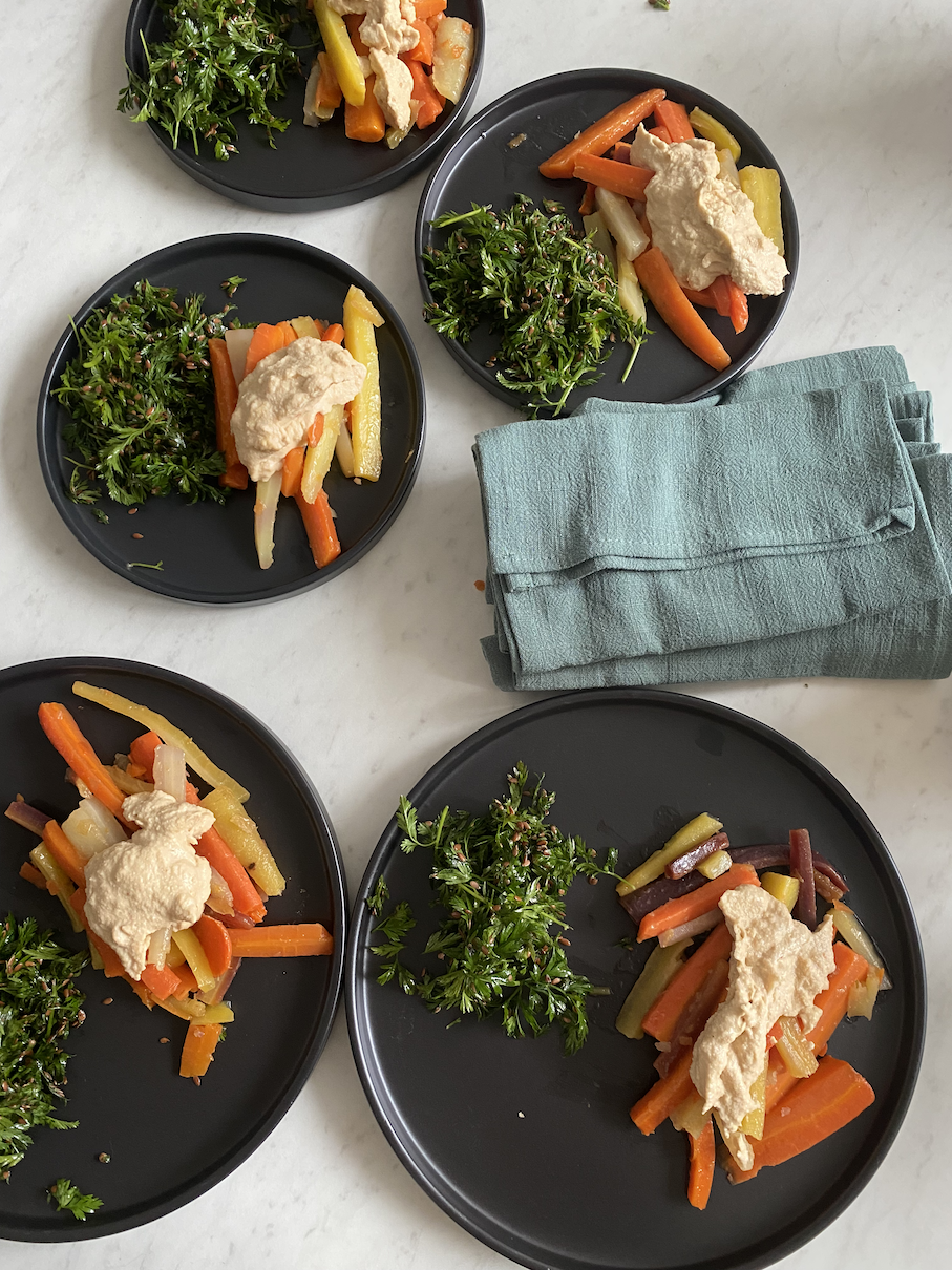 The homemade, organic snack plate has glazed carrots with cashew cream sauce and carrot leaf salad. Carrots signified the womb area with their orange color and the underground work we were doing in this ritual.