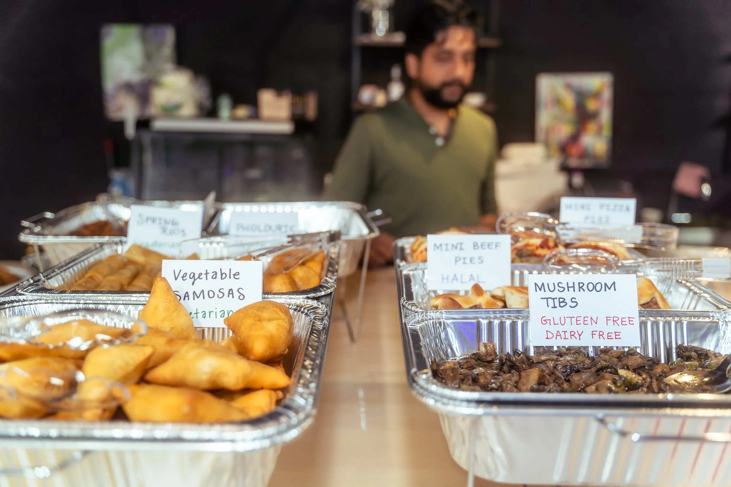 Close up photo of vegetable samosas tray and mushroom tibs tray.