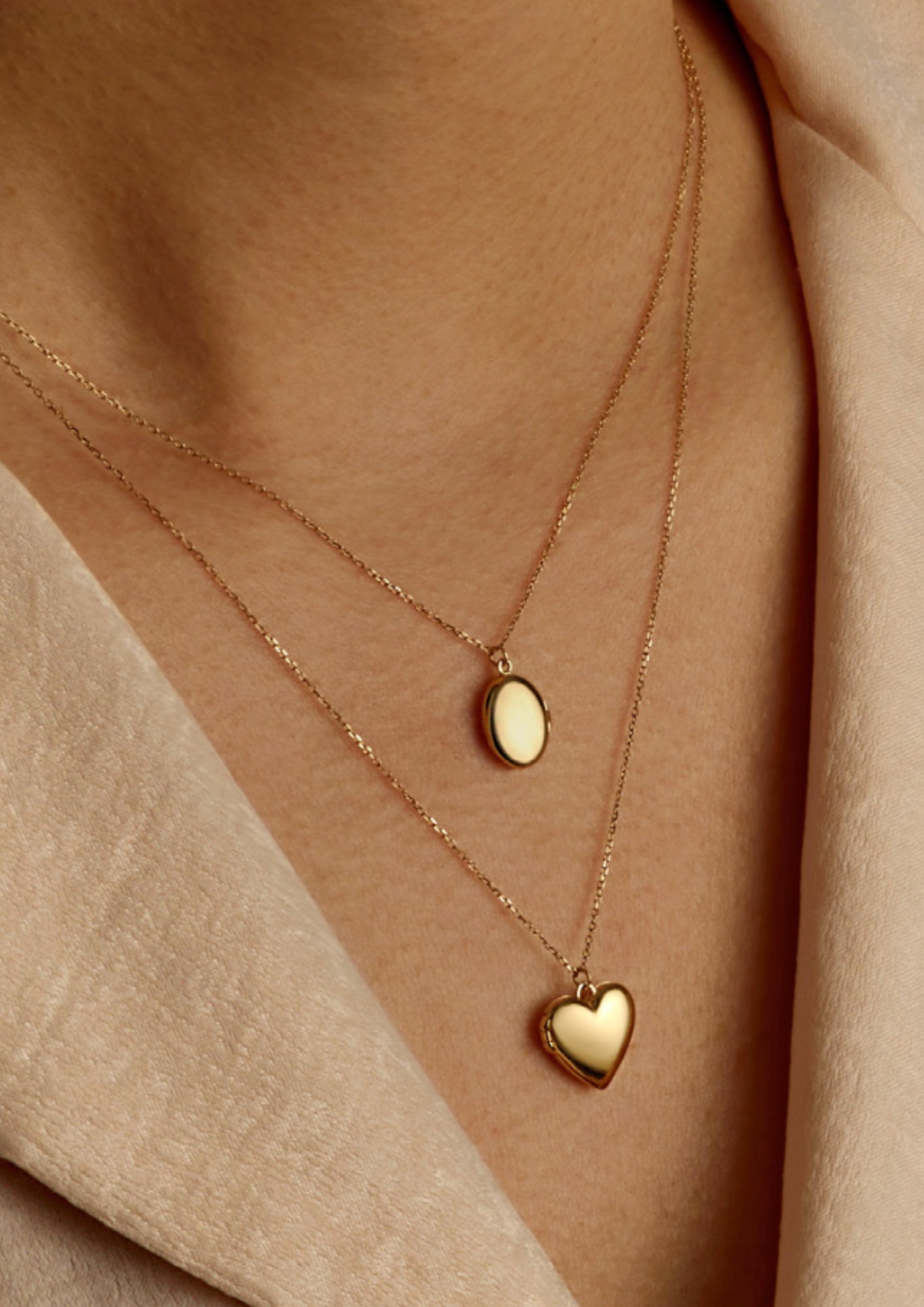 Layered 14k gold necklaces with engravable oval charm and heart locket, keepsake jewelry